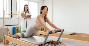 Mulher adulta praticando pilates em aparelho reformer em estúdio moderno, enquanto nutricionista em jaleco observa com prancheta nas mãos, representando integração entre pilates, nutrição, emagrecimento saudável e recuperação física em Toledo e Guaíra, Paraná.
